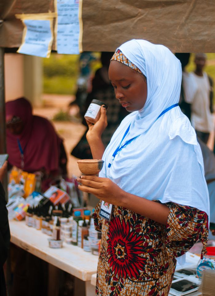 Crafting Captivating Headlines: Your awesome post title goes here A young woman vendor showcasing natural products at an outdoor market stall